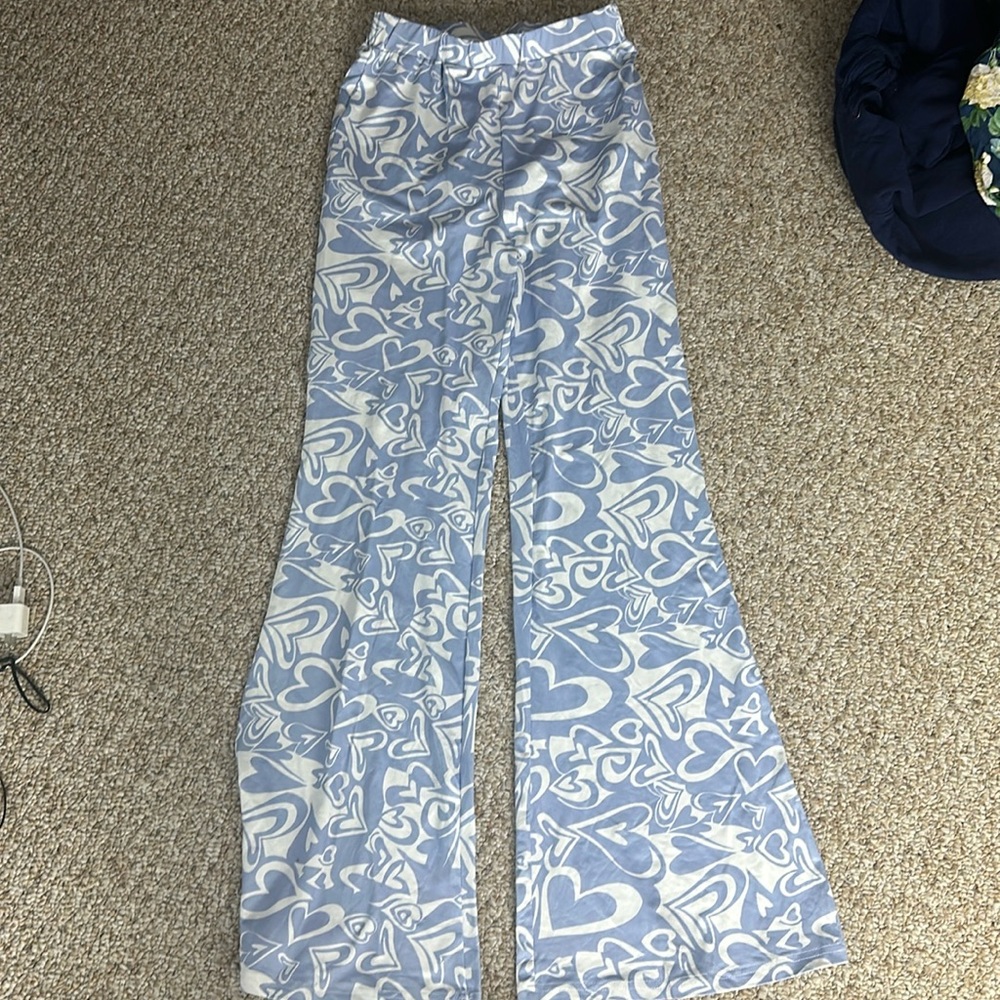 Light blue flare pants with white heart designs.